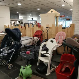 Verzameling tweedehands kinderwagens, autostoeltjes en babyartikelen in de winkel