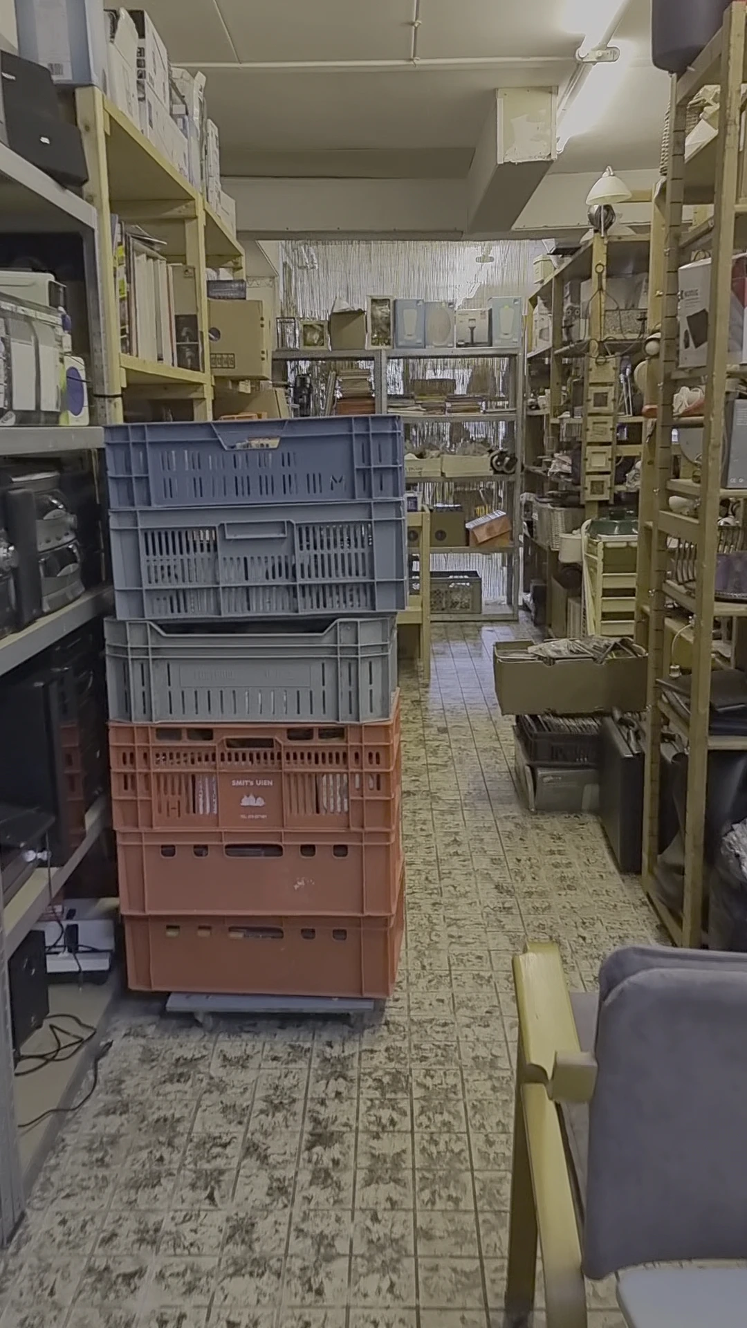 Kringloopwinkelpad met gestapelde plastic kratten in verschillende kleuren
