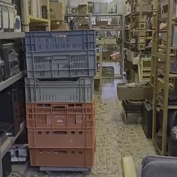 Kringloopwinkelpad met gestapelde plastic kratten in verschillende kleuren