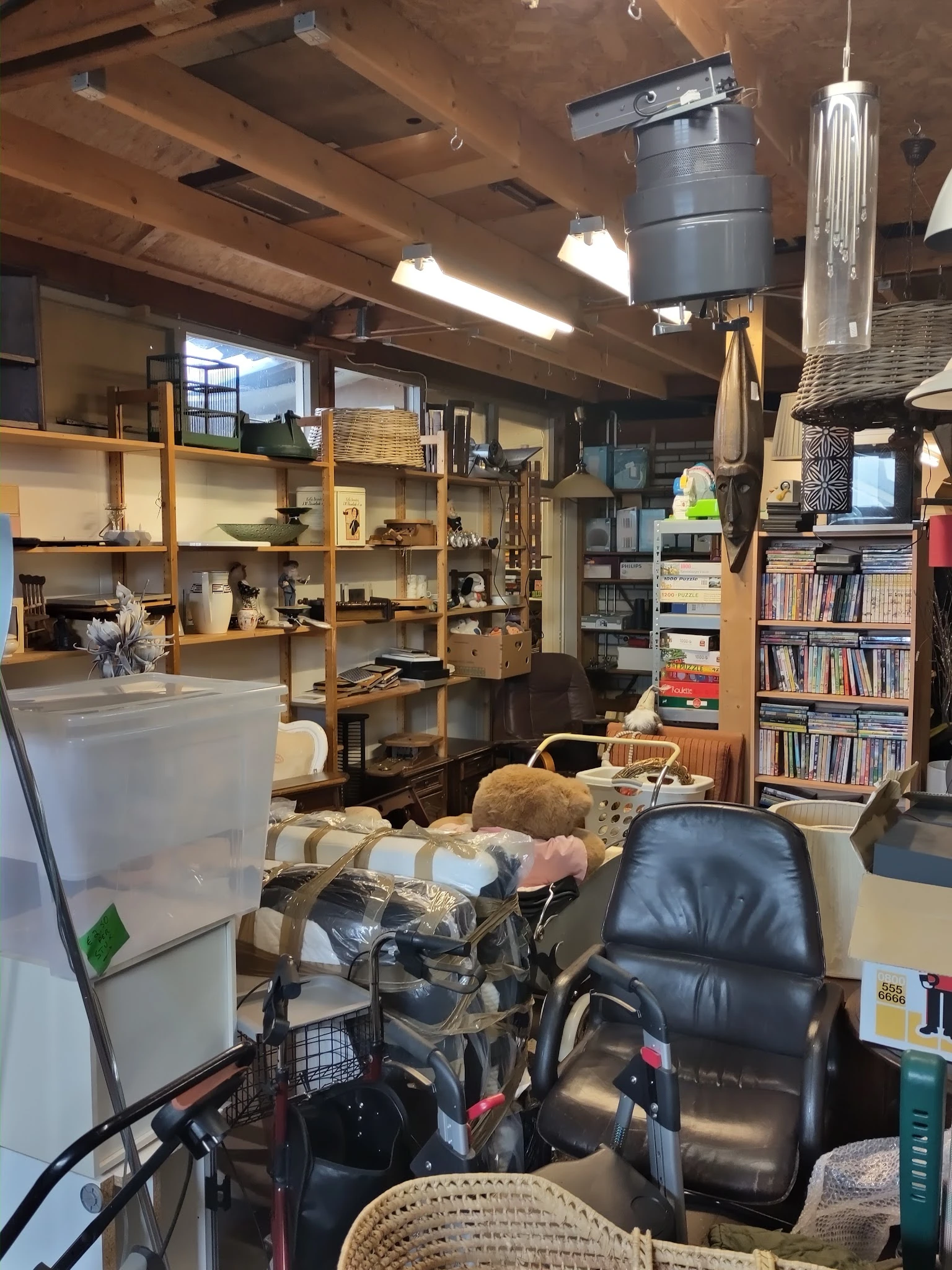 Winkelvloer met houten stellingen, boekenkasten, zitmeubels en diverse tweedehands artikelen