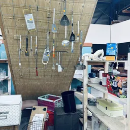 Winkelinterieur met stellingen vol kookgerei, keukentextiel en huishoudartikelen