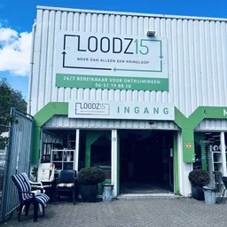 Groene en witte gevel van kringloopwinkel Loodz15 met entree en openingsuren