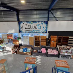Overzicht van kringloopwinkel met kasten, meubels, dozen met spullen en rekken met huishoudartikelen