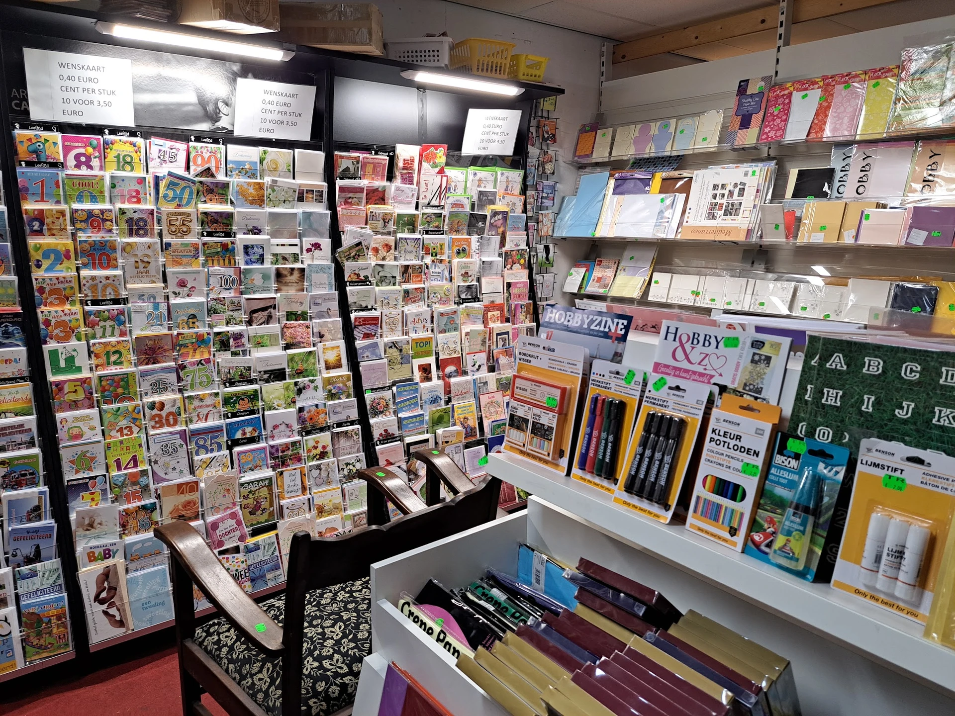 Uitgebreide collectie ansichtkaarten en kaarten op displayborden en schappen in de winkel