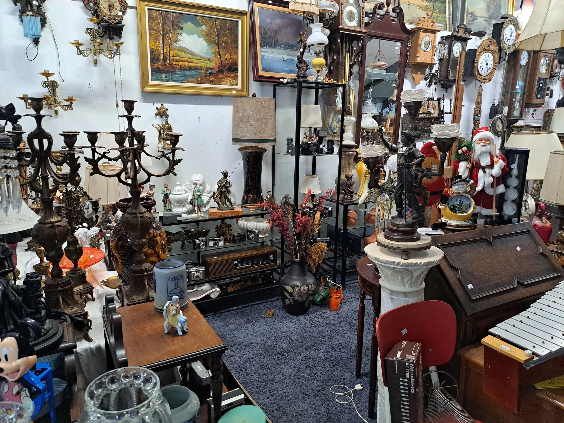 Overzicht van kringloopwinkelruimte met diverse meubels, decoratieartikelen, kandelaars, beelden en vintage spullen
