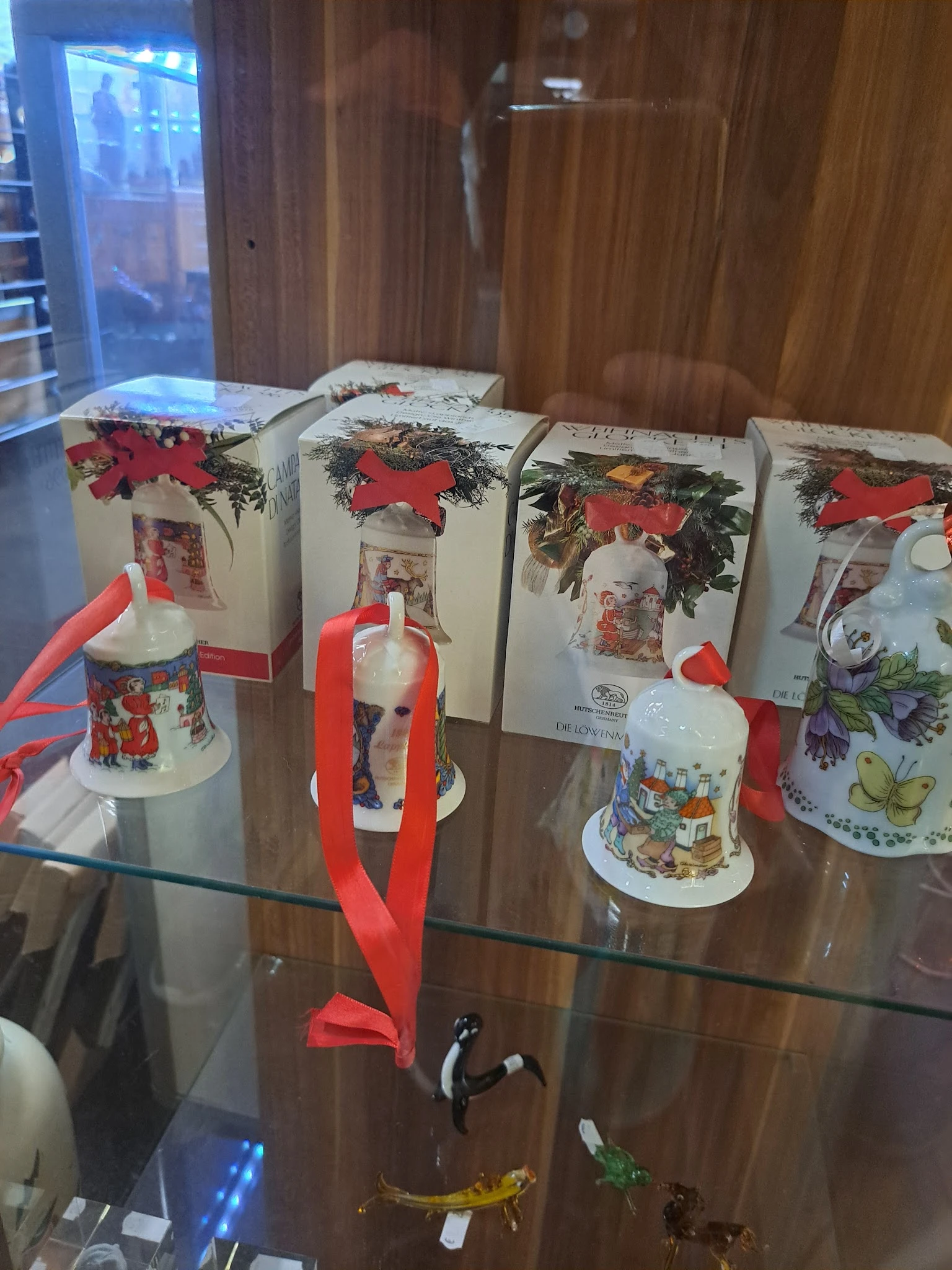 Verzameling kerstdecoraties en -ornamenten in dozen en losse items op een glazen toonbank