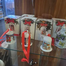 Verzameling kerstdecoraties en -ornamenten in dozen en losse items op een glazen toonbank