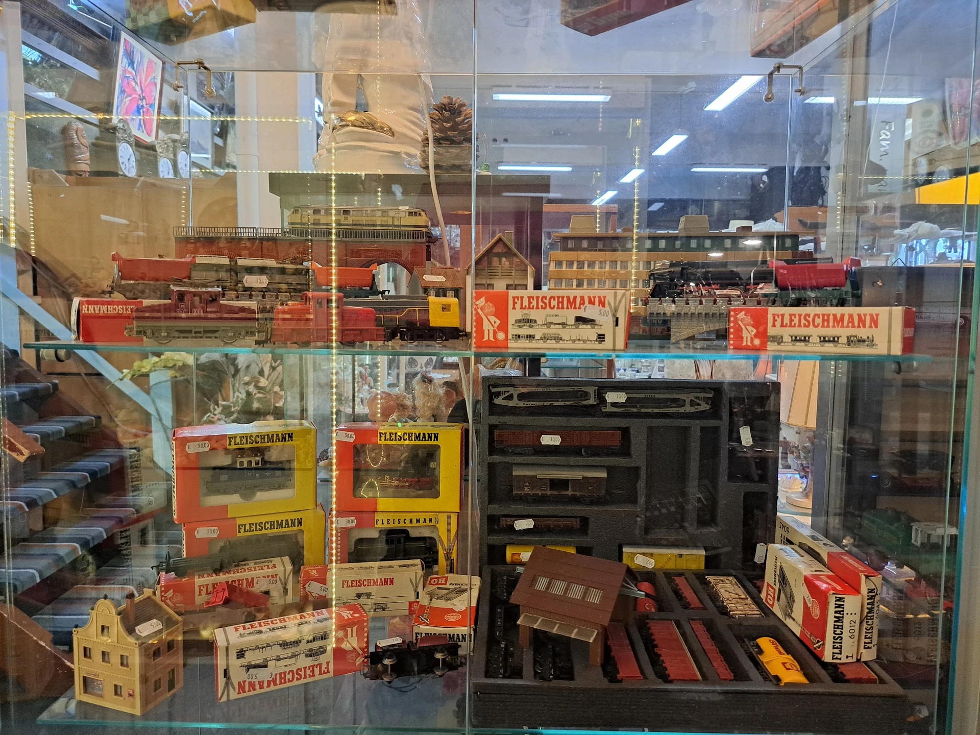 Vitrinekast met uitgestalde miniatuurtreinen en modelspoorwegen van merk Fleischmann
