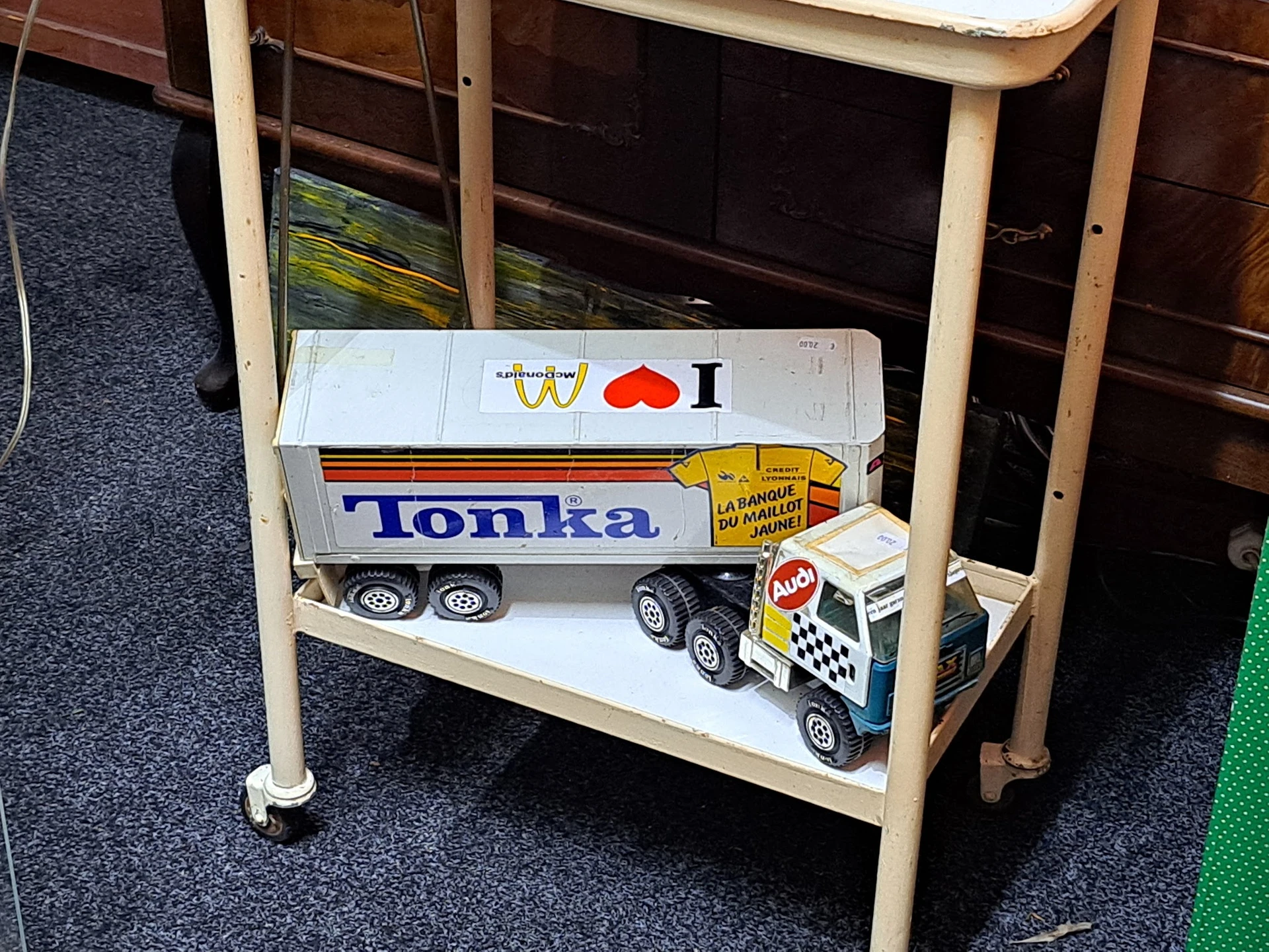 Tonka speelgoedvrachtwagen en politieauto op een houten schap