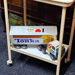 Tonka speelgoedvrachtwagen en politieauto op een houten schap