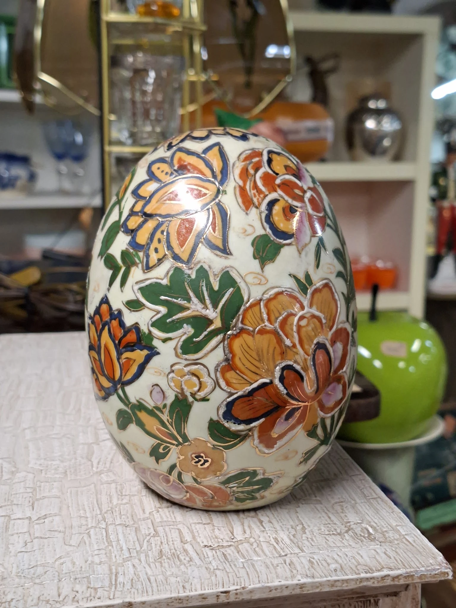 Decoratief wit ei met handgeschilderde bloemen in oranje, geel en groen