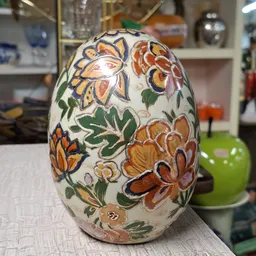 Decoratief wit ei met handgeschilderde bloemen in oranje, geel en groen