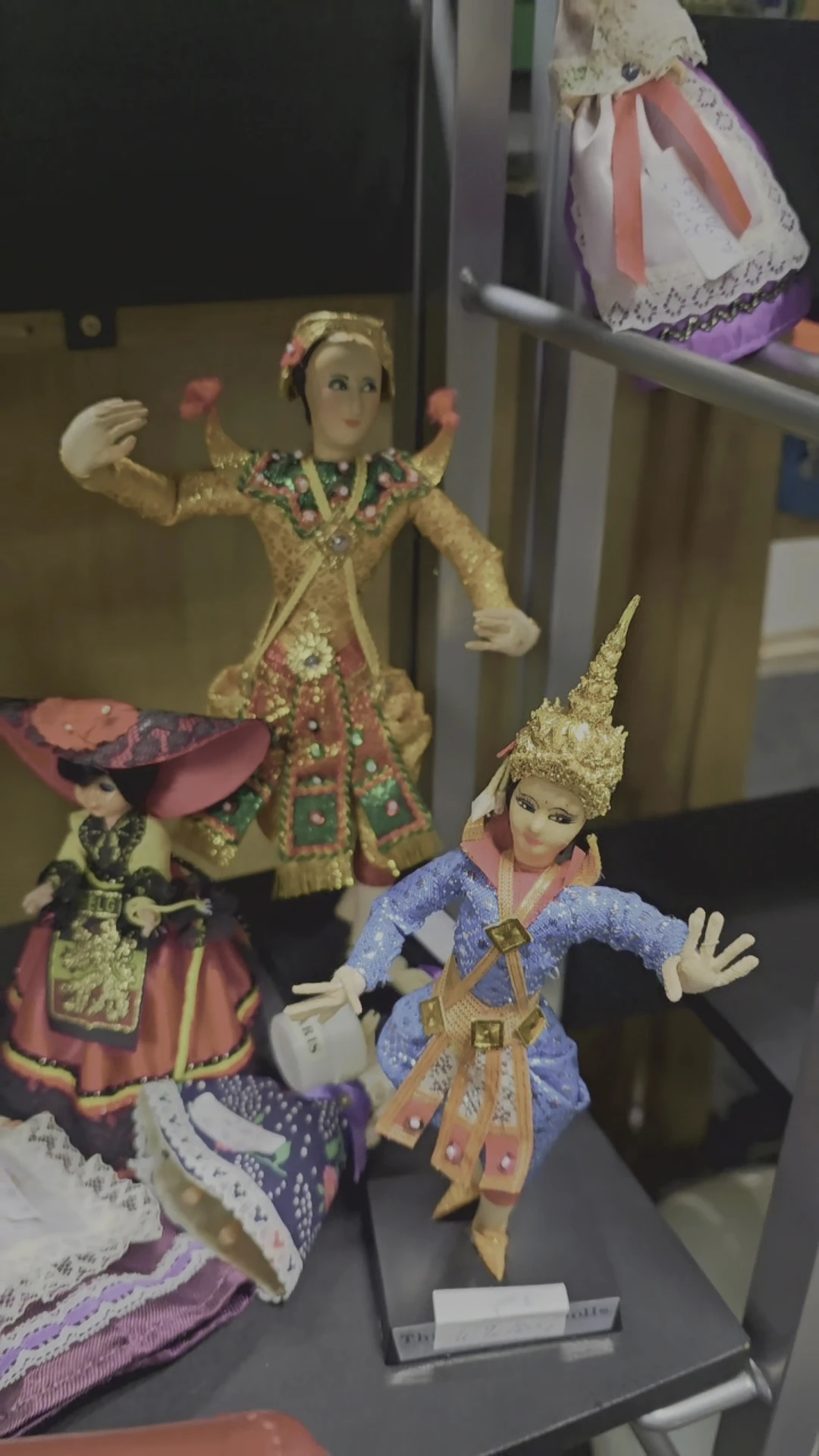 Twee decoratieve poppen in traditionele Aziatische klederdracht met gouden en blauwe outfits