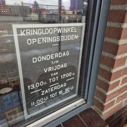 Openingstijden op een raam: donderdag tot vrijdag 13.00-17.00 uur, zaterdag 11.00-15.30 uur