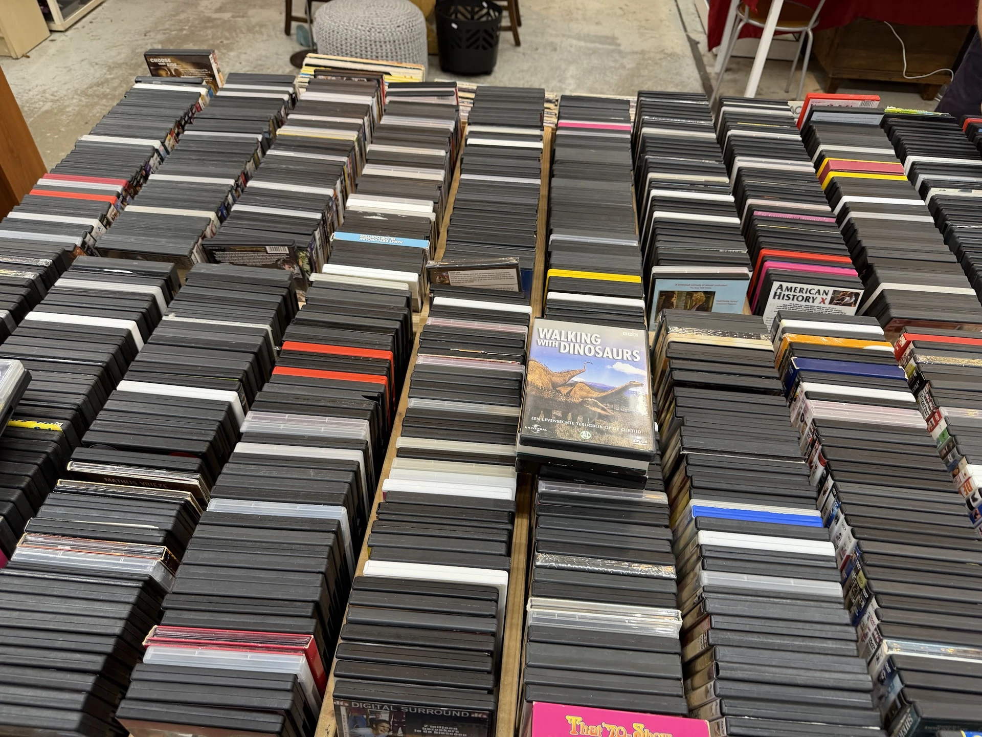 Grote verzameling cd's en dvd's uitgestald in dozen op de grond van de winkel