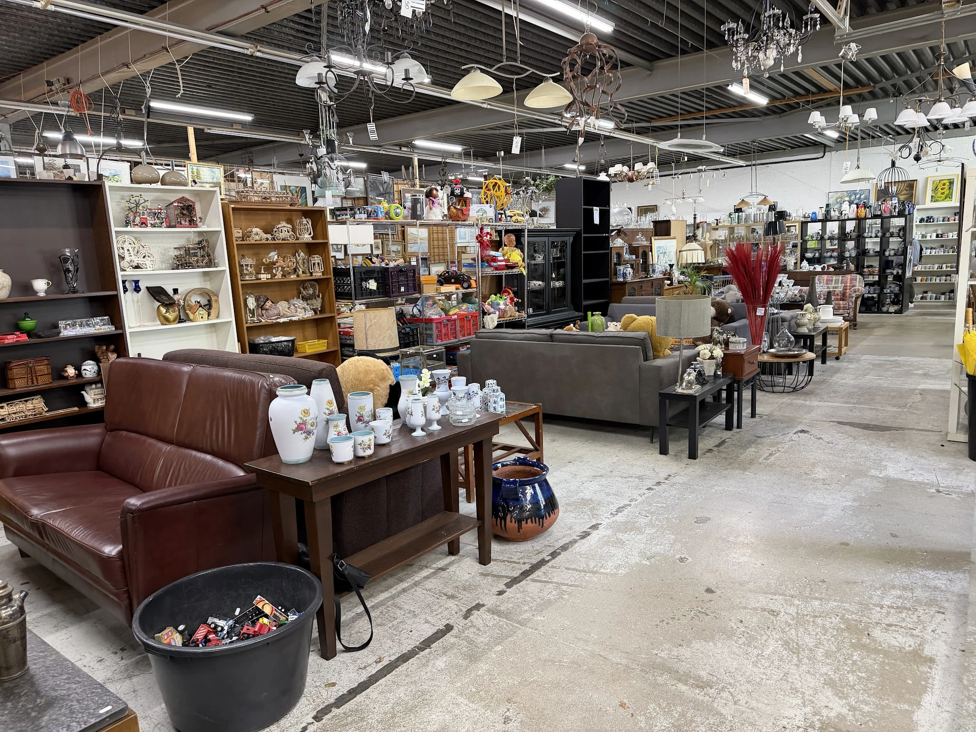 Winkelvloer van kringloopwinkel met meubels, huishoudartikelen en decoratieartikelen uitgestald