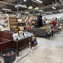 Winkelvloer van kringloopwinkel met meubels, huishoudartikelen en decoratieartikelen uitgestald