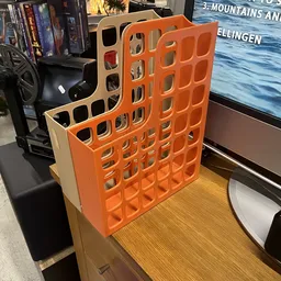 Oranje kunststof organizer met vierkante vakken, staand op houten oppervlak in winkel