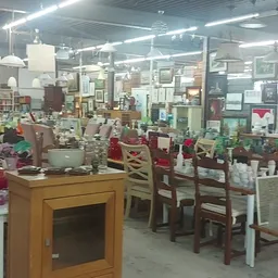 Overzicht van de winkelvloer met diverse meubels, stoelen, kastjes en decoratieve items uitgestald
