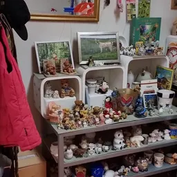 Uitgestalde verzameling knuffels, beeldjes en decoratieartikelen in planken en op een tafel