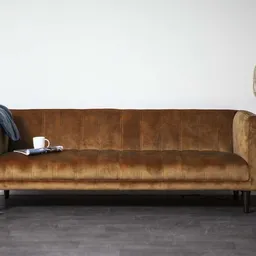 Bruinleren vintage bank met houten poten tegen witte muur, met accessoires ernaast