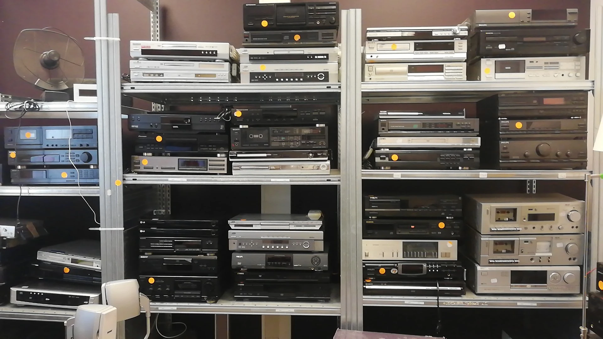 Stellingen met tweedehands audio- en elektronicaapparatuur, waaronder versterkers, tuners en andere stereocomponenten