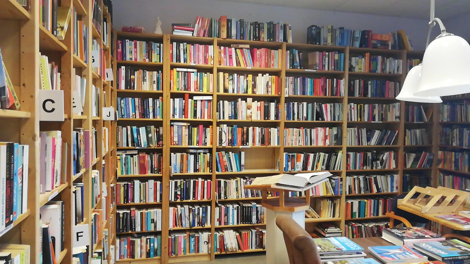 Uitgebreide boekenkasten met honderden tweedehands boeken in verschillende kleuren en genres