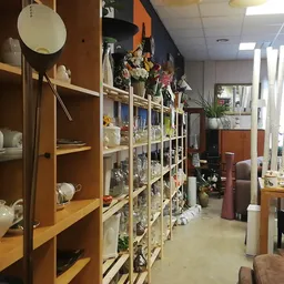 Winkelinterieur met houten stellingen vol met huishoudartikelen, servies en decoratie