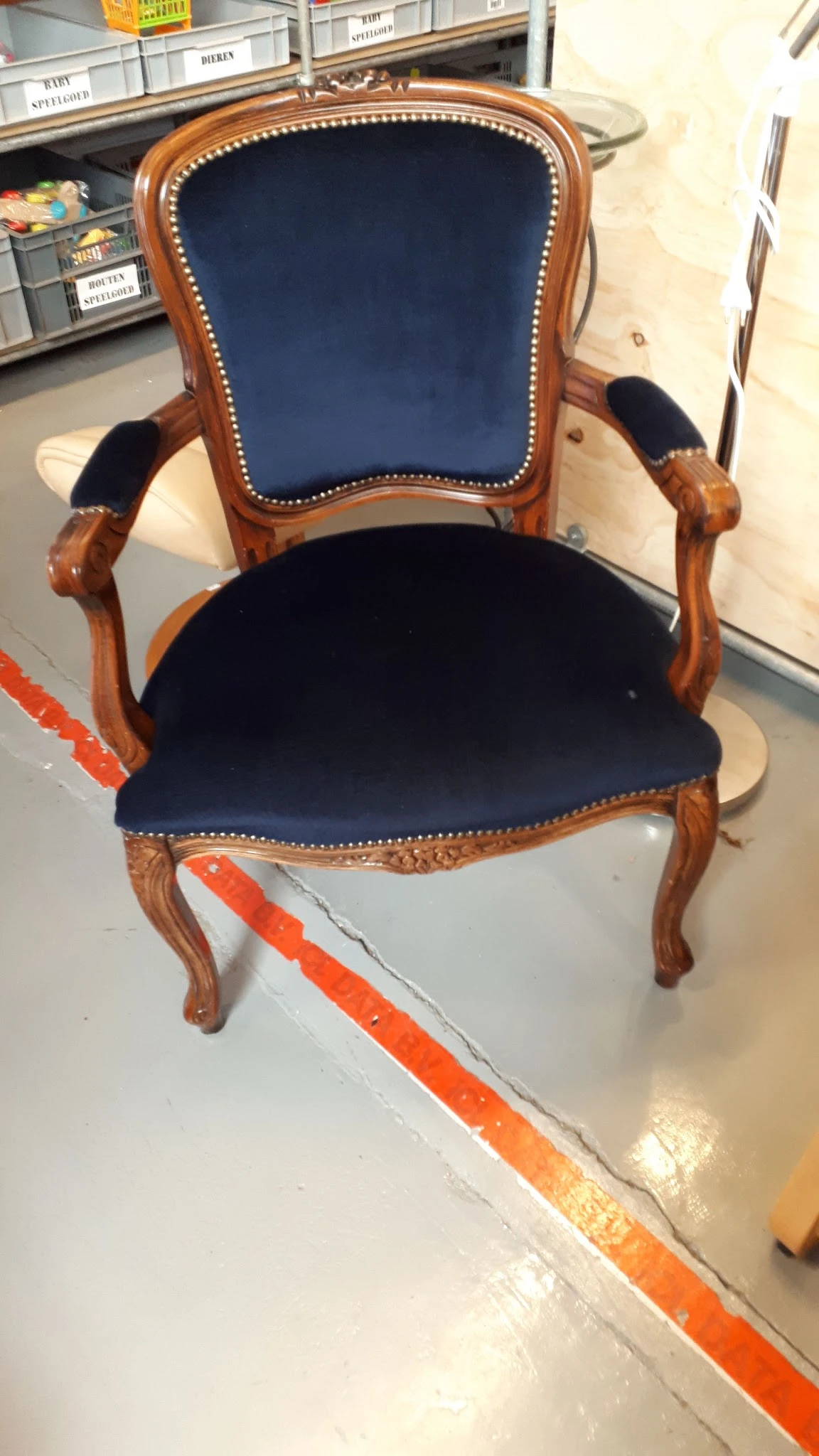 Houten fauteuil met donkerblauwe fluweelbekleding en koperen siernagels, van bovenaf gefotografeerd