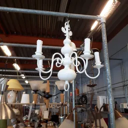 Witte kroonluchter met zes armen en kaarsen, hangend in de winkel