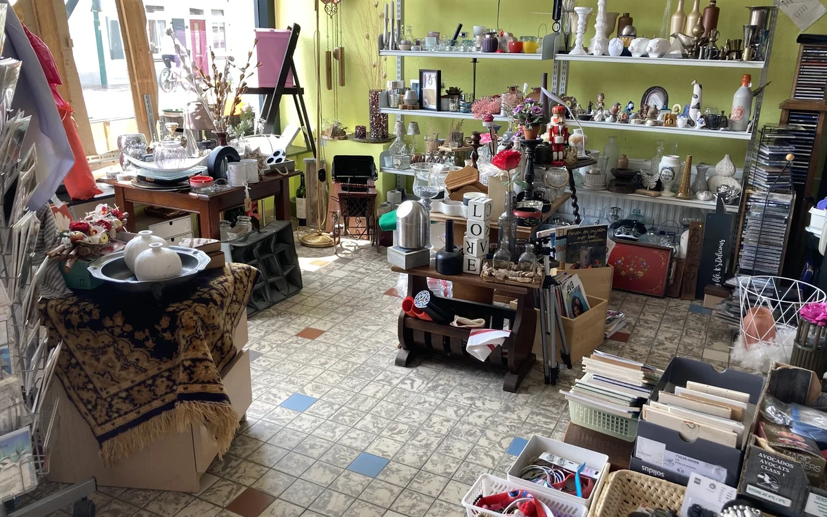 Winkelvloer met stellingen, toonbanken en diverse spullen in een kringloopwinkel
