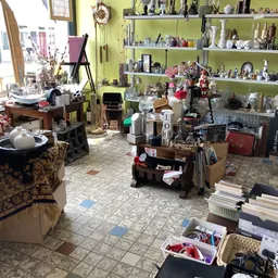 Winkelvloer met stellingen, toonbanken en diverse spullen in een kringloopwinkel