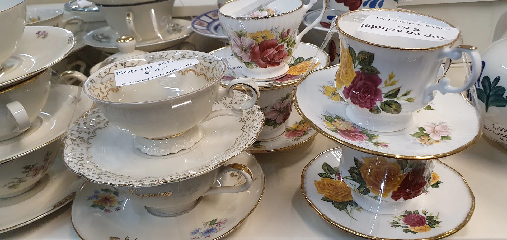 Collectie antieke porseleinen kopjes en schotels met bloemmotieven en gouden randen