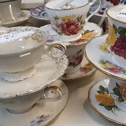 Collectie antieke porseleinen kopjes en schotels met bloemmotieven en gouden randen