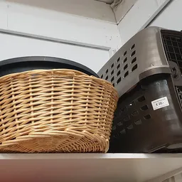 Twee manden en een kunststof kratten op een plank, waaronder een prijs van 2,50 euro zichtbaar is