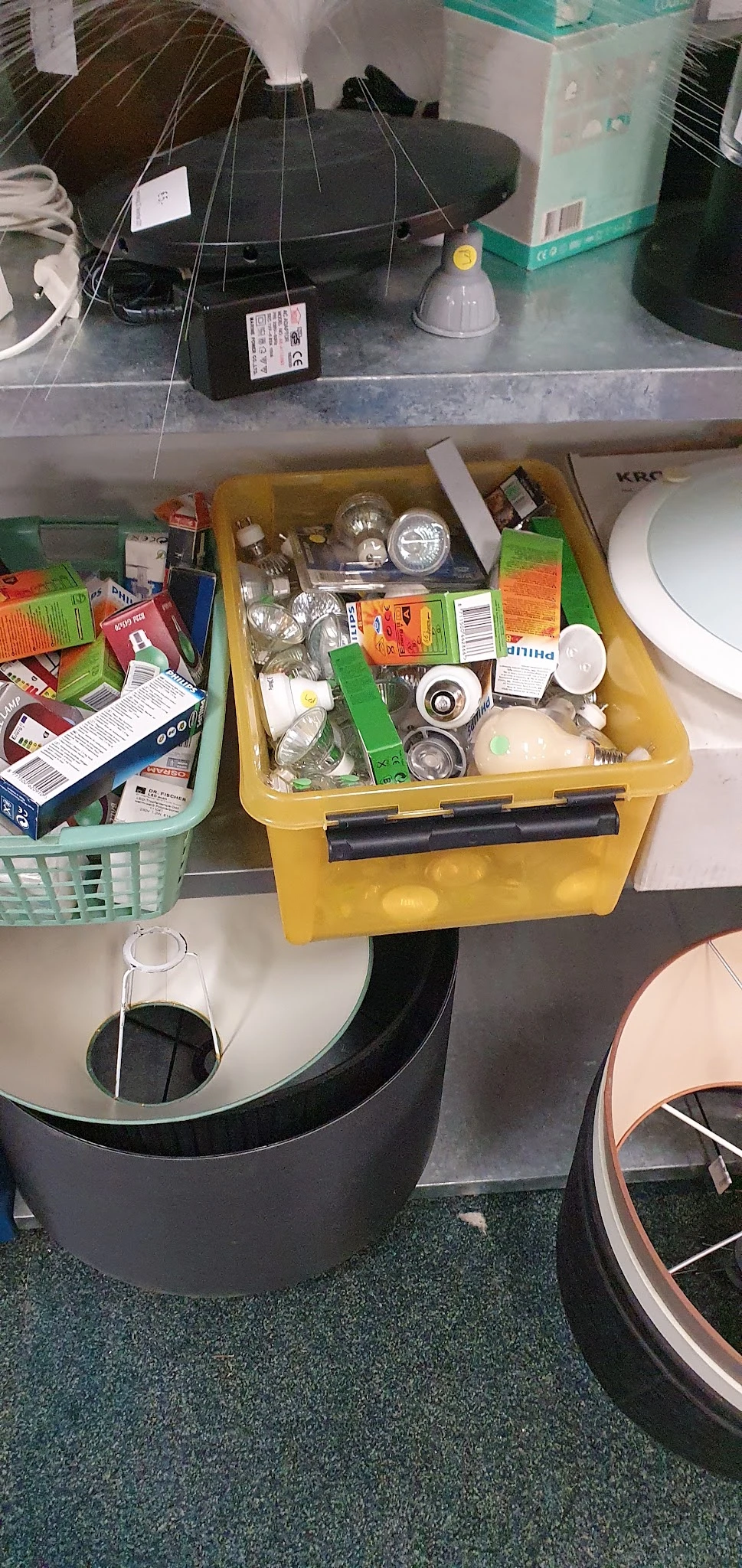 Gele opbergdoos met diverse huishoudelijke artikelen en onderdelen, zoals lampen, schakelaars en kleine spullen