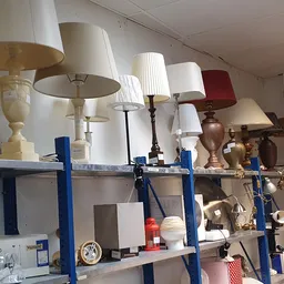 Blauwe stellingen met diverse tafellampjes en lampenkappen in verschillende stijlen en kleuren