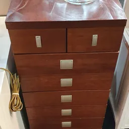 Houten ladekast met zes laden en metalen handgrepen, afkomstig uit een kringloopwinkel