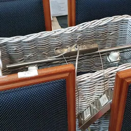Witte rieten mand met tweedehands huishoudartikelen en keukengerei