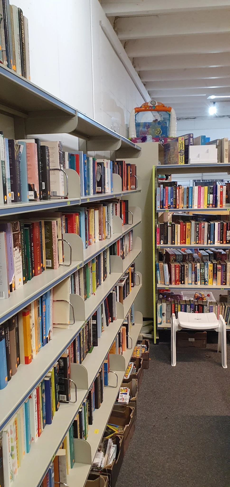 Metalen boekenkasten met boeken en dvd's netjes uitgestald in de winkel