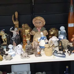 Verzameling van beeldjes, speelgoed en decoratieve objecten op een witte tafel tegen zwarte achtergrond