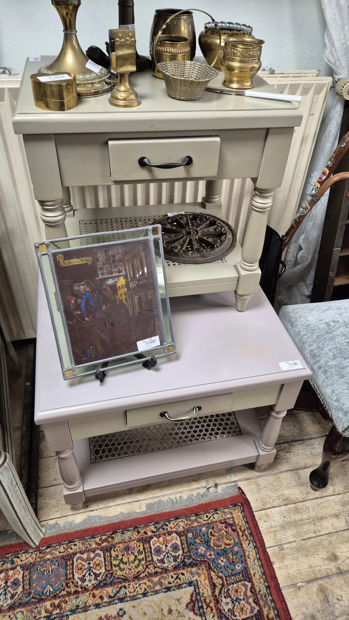 Tweedehands schilderij in glazen lijst op witte tafel met decoratieve voorwerpen op de achtergrond