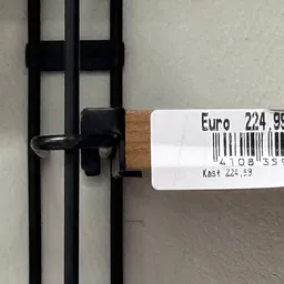 Prijssticker op zwart metalen voorwerp met Euro 224,99 en barcode