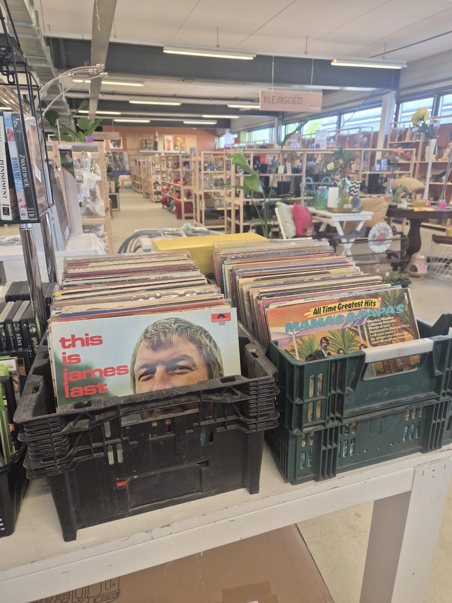 Zwarte plastic kratten met vinyl-LP's en platen in een kringloopwinkel