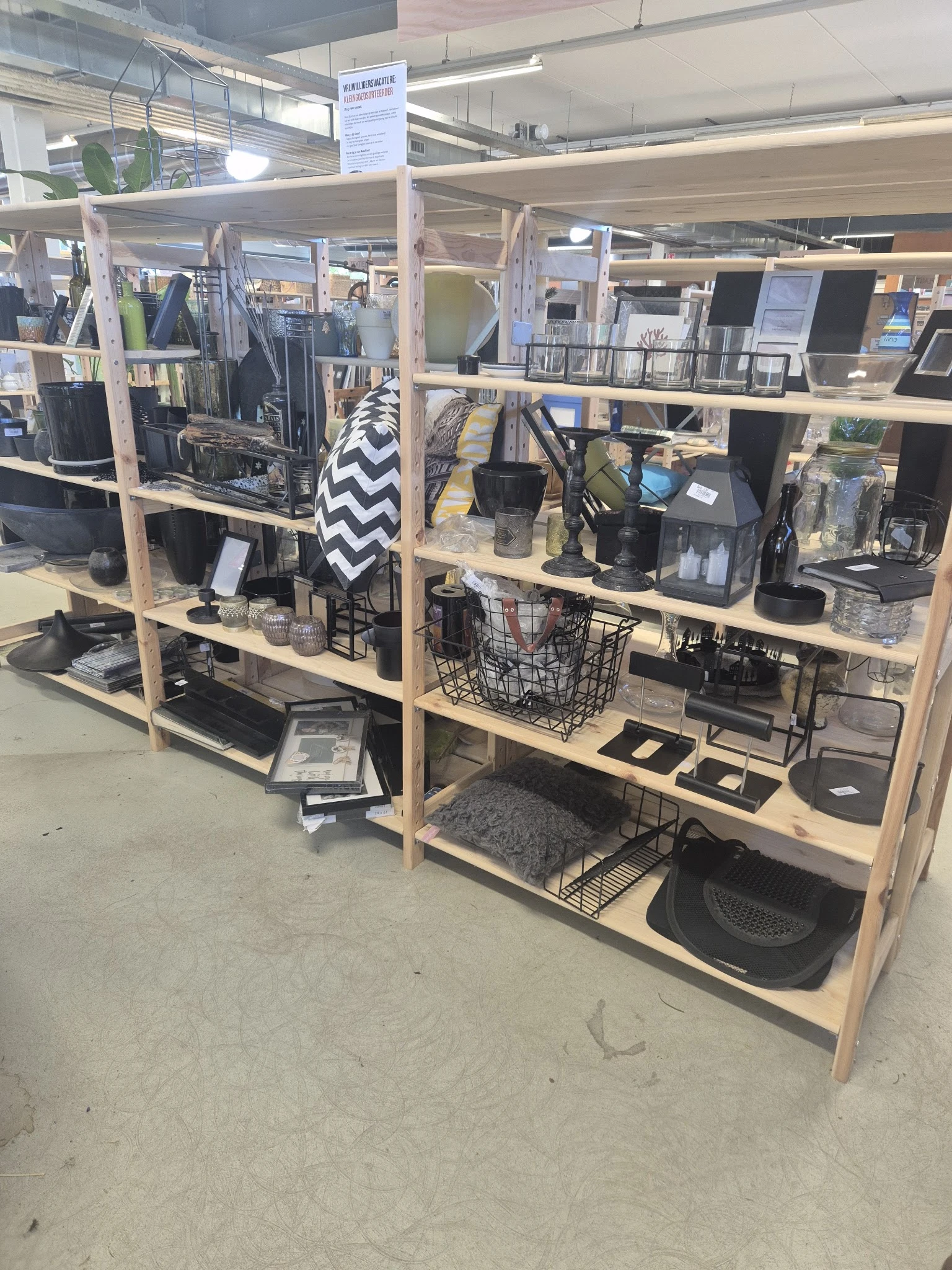 Houten stellingen met tweedehands huishoudelijke artikelen en accessoires