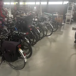 Rij met zwarte en gekleurde fietsen uitgestald in de winkel