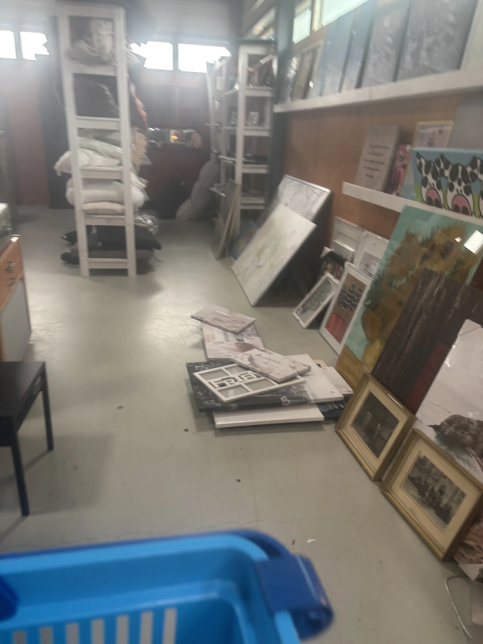 Uitgestalde schilderijen, kunstwerken en ingelijste prints op de winkelruimte