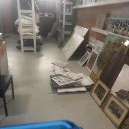 Uitgestalde schilderijen, kunstwerken en ingelijste prints op de winkelruimte