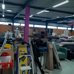 Ruim winkelinterieur met meubels, stellingen en diversen spullen uitgestald
