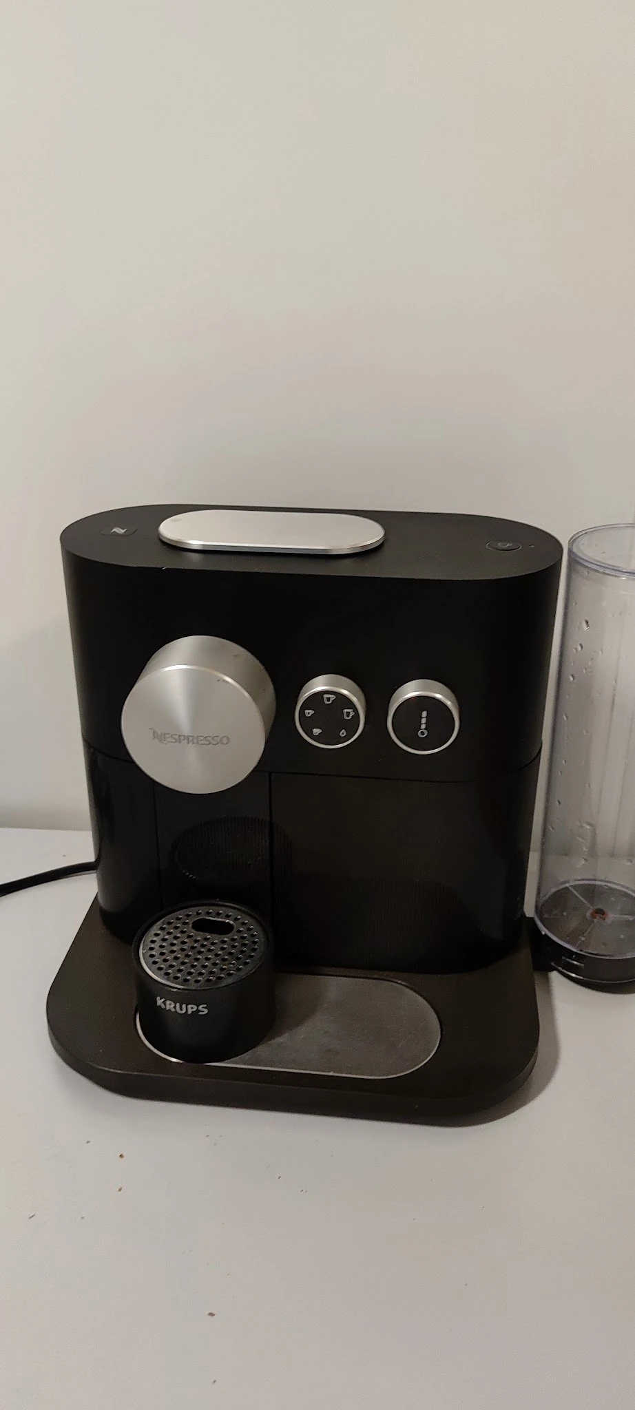 Nespresso-koffiemachine in zwart met zilveren accenten, close-up van het apparaat